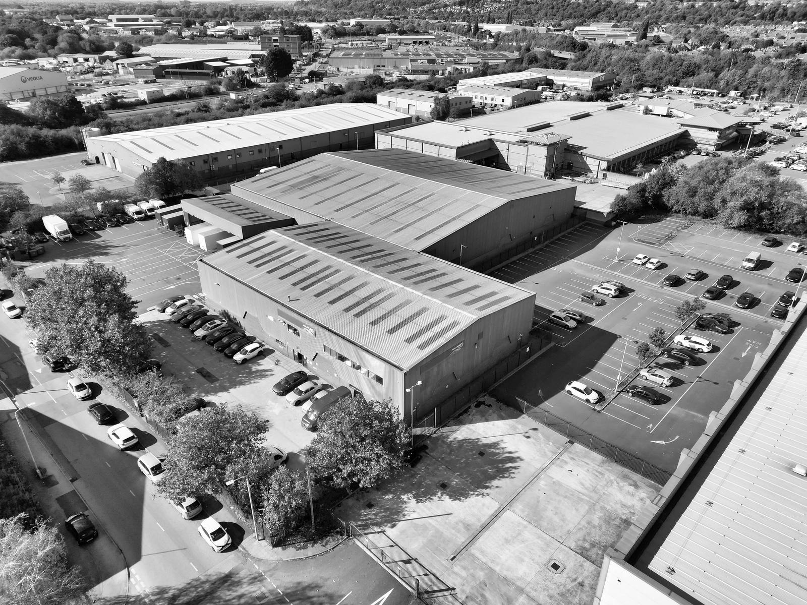 Aerial view of a British industrial estate, muted monochrome.